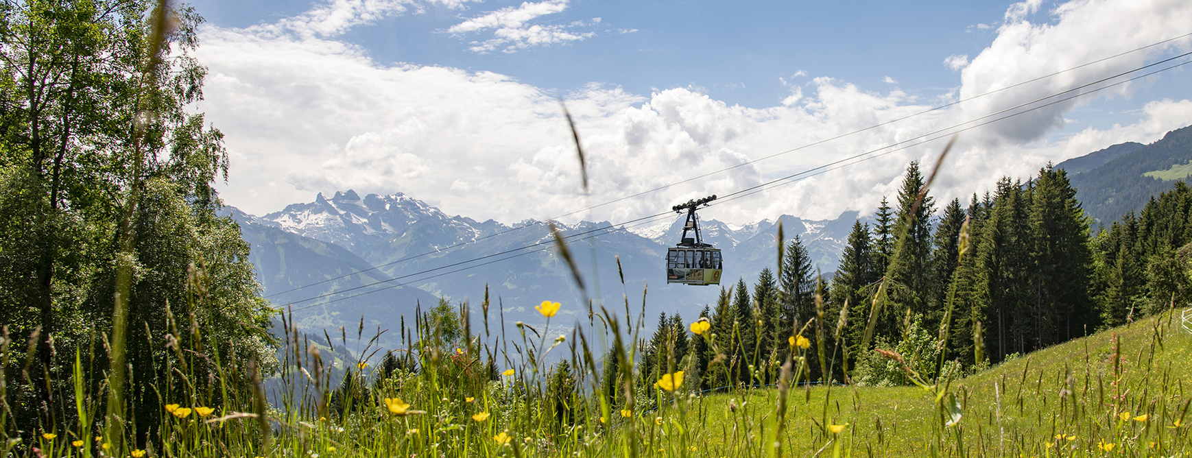 The Montafoner Kristbergbahn glides above Silbertal – with the impressive panorama of the Drei Türme in the Rätikon mountains of the Austrian Alps in the background.