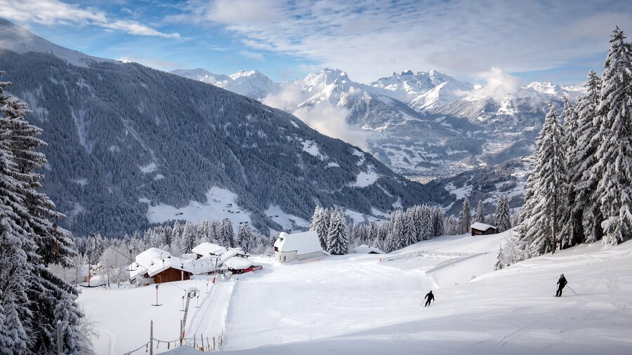 Perfekt präparierte Skipiste am Kristberg im Silbertal, dem Genießerberg im Montafon, mit verschneiter St. Agatha Kirche und Panoramablick auf das Verwall- und Rätikongebirge in den österreichischen Alpen. | © Montafon Tourismus GmbH - Andreas Haller