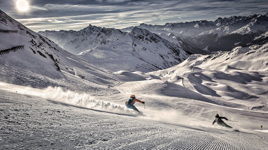 Perfekt präparierte Skipiste mit zwei sportlichen SkifahrerInnen im Skigebiet Silvretta Montafon – dem größten und sportlichsten Skigebiet im Montafon Brandnertal in den österreichischen Alpen. | © Silvretta Montafon Bergbahnen GmbH, Daniel Zangerl